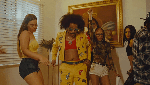 a group of people are dancing in front of a framed picture