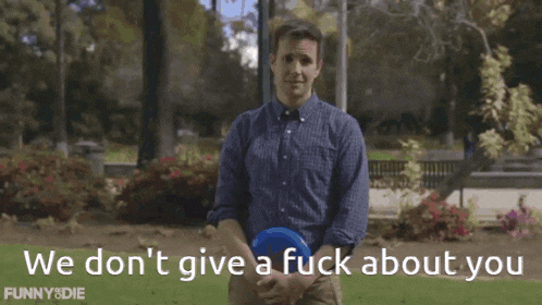 a man holding a frisbee with the words we don 't give a fuck about you behind him