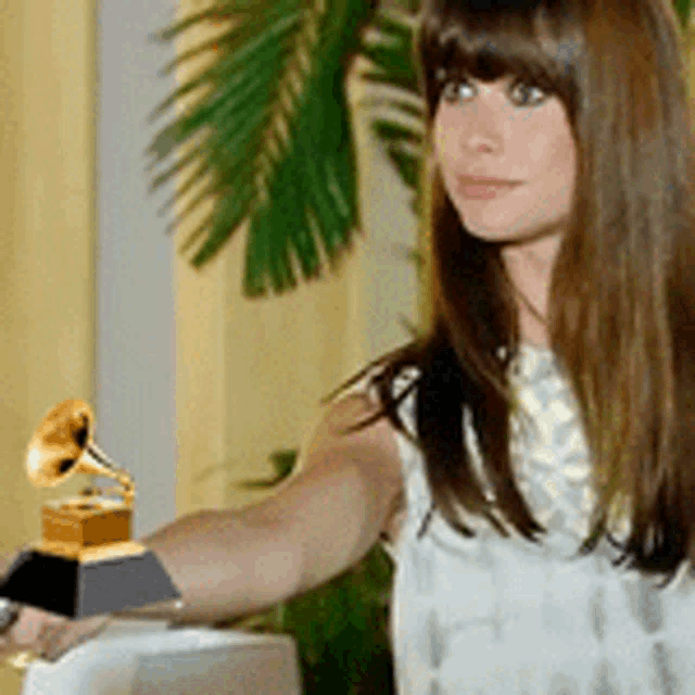 a woman is holding a grammophone in her hand