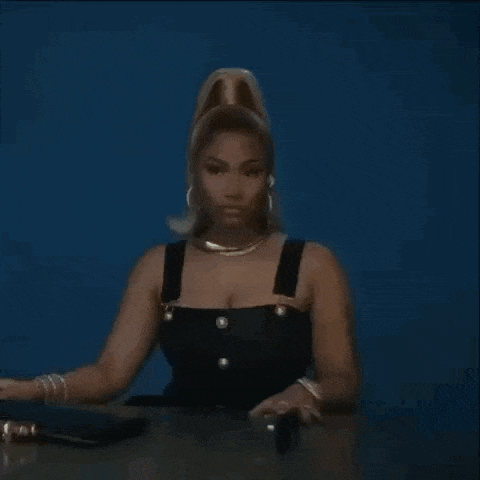 a woman with blonde hair is sitting on a chair in front of a blue background .
