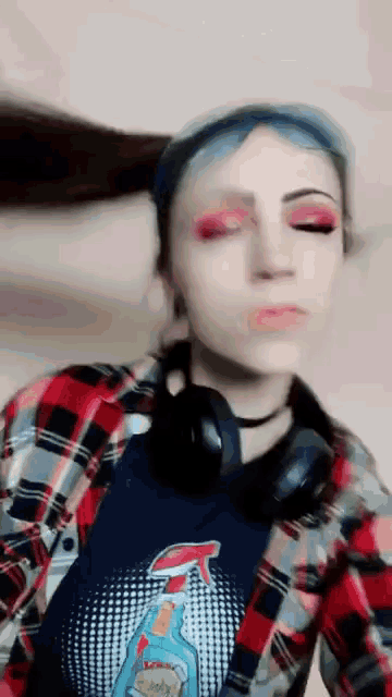 a woman in a plaid shirt with a spray bottle on it