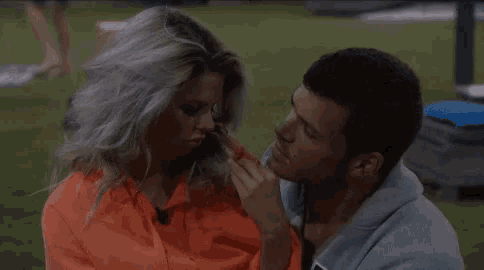a man and a woman are sitting next to each other on a lawn .