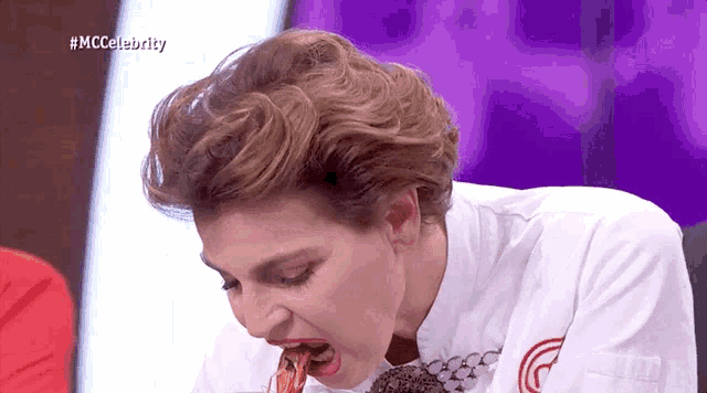 a woman in a chef 's uniform is eating a piece of food with the hashtag #mccelebrity on the bottom right