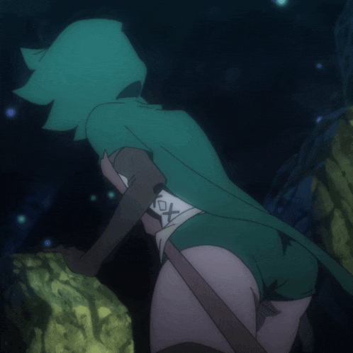 a girl in a green hooded cape has the letter x on her back