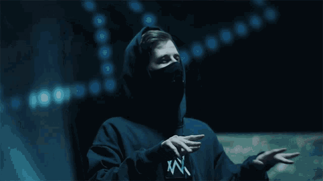 a man wearing a black hoodie with the letter w on the front