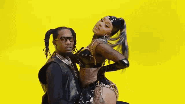 a man and a woman are posing for a picture on a yellow background .