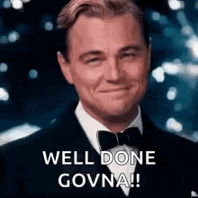 a man in a tuxedo and bow tie is smiling and saying `` well done govna '' .