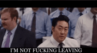 a man in a suit and tie says " i 'm not fucking leaving " in front of a crowd of people