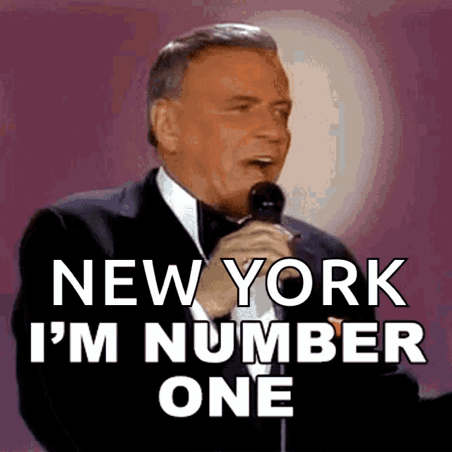 a man singing into a microphone with the words new york i 'm number one behind him