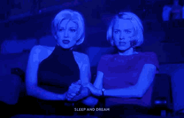 two women are holding hands while watching a movie and the words sleep and dream are displayed above them