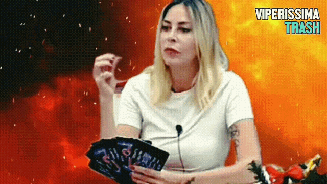 a woman in a white shirt is holding a tarot card and the words viperissima that are on the bottom