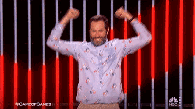 a man with his arms in the air and a nbc logo in the background