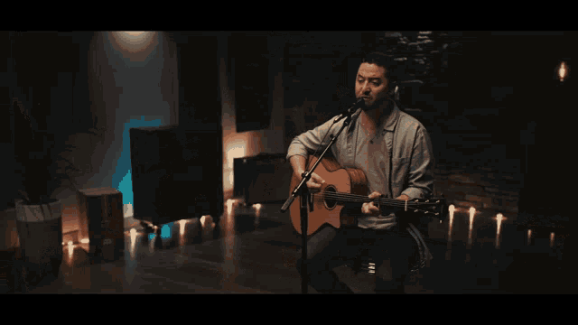 a person is playing an acoustic guitar with a watch on their wrist