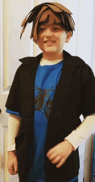 a young boy wearing a blue shirt and a black jacket is smiling