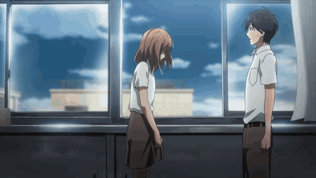 a boy and a girl are standing in front of a window looking at each other