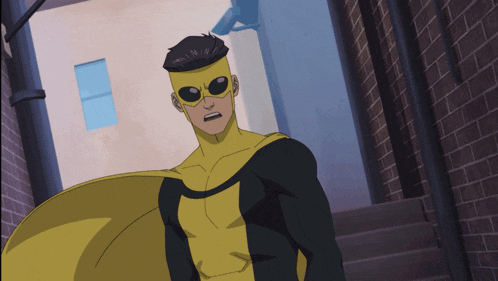 a man in a yellow and black superhero costume stands in an alleyway