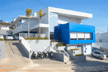 a blue and white building with a lot of cars parked in front of it