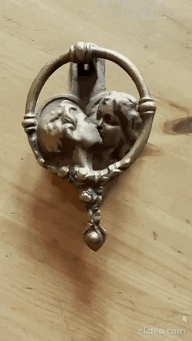 a close up of a door knocker with two people kissing on it