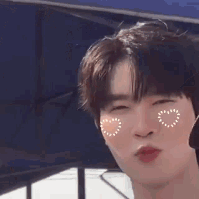 a close up of a person making a funny face with hearts on their face .