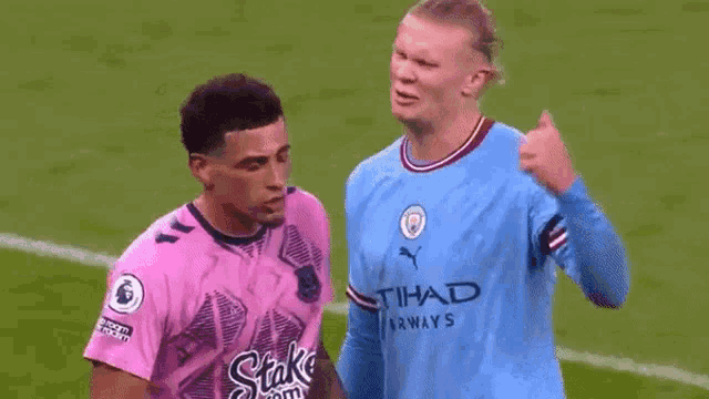two soccer players on a field with one wearing a pink shirt that says stake