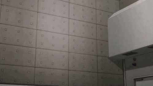 a pink object is sitting in front of a gray wall