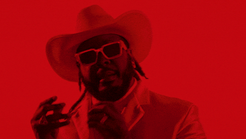 a man wearing a cowboy hat and white sunglasses
