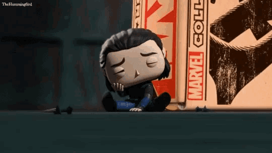 a funko pop of loki sits next to a box that says marvel collection