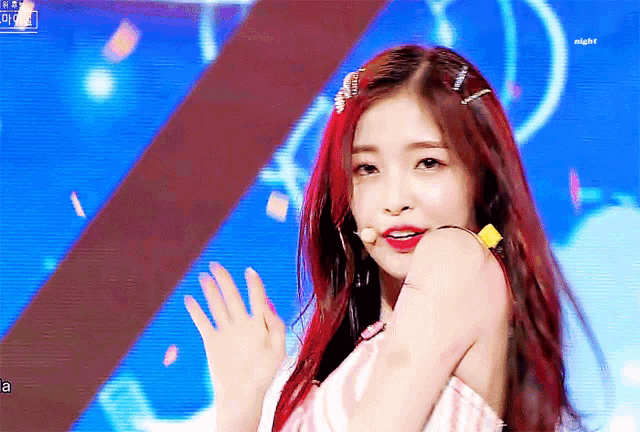 a girl with red hair is on a stage and the word night is on the bottom