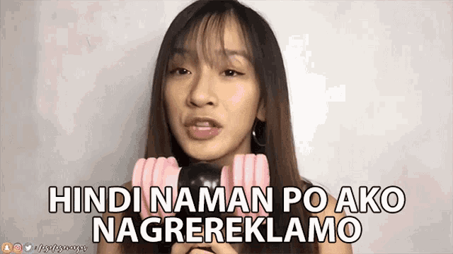 a woman holding a microphone with the words hindi naman po ako nagrereklamo written below her