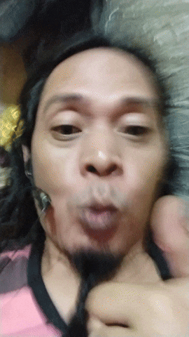 a man with long hair and a beard making a face