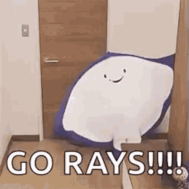a stuffed manta ray with a smile on its face is sitting in a room .