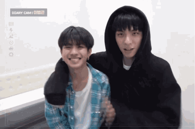 two young men are standing next to each other with the words diary cam 1 on the bottom right