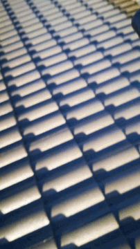 a row of white tiles on a roof casting shadows