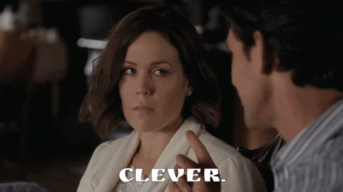 a man and a woman are talking and the woman is pointing at the man and says clever