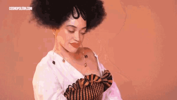 the woman is wearing a striped dress and a white shirt and is sitting down .