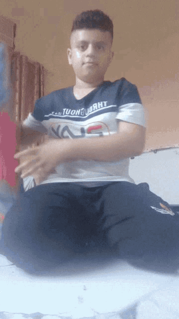 a young man wearing a t-shirt that says tuong hanh is kneeling down