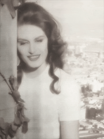 a black and white photo of a woman with a rose around her neck