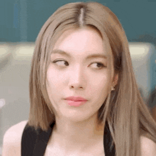 a close up of a woman 's face with long blonde hair making a funny face .