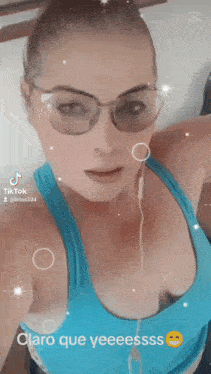 a woman wearing sunglasses and a blue tank top says claro que yeessss