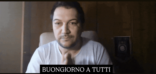 a man sitting in a chair with the words buongiorno a tutti written above him