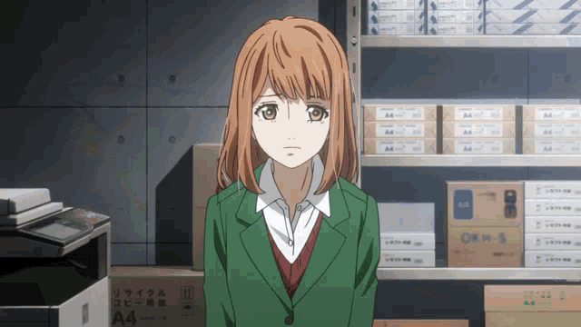 a girl in a green jacket stands in front of a shelf full of a4 boxes