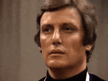 a close up of a man 's face with a black turtleneck
