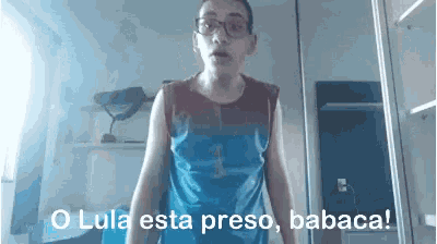 a man wearing glasses and a blue tank top says lula esta preso babaca