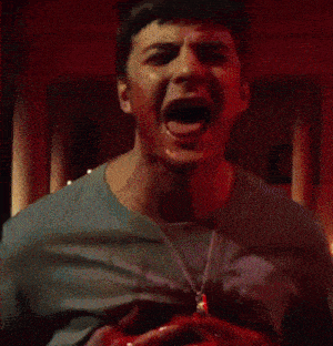 a man with his mouth open is holding a bloody object