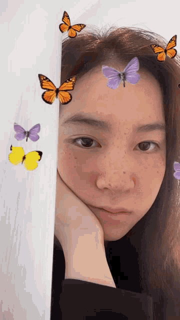 a woman with butterflies on her forehead looks tired