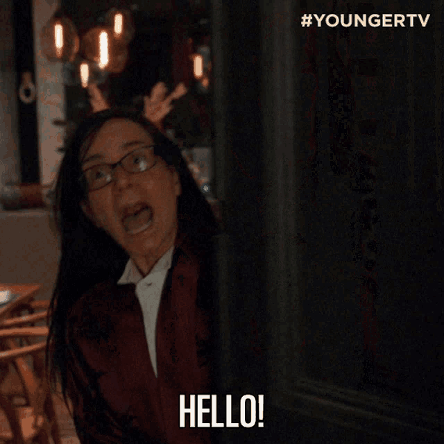 a woman in glasses says hello to another woman in a restaurant