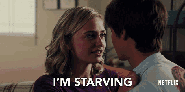 a man and a woman are sitting on a couch with the words i 'm starving on the bottom
