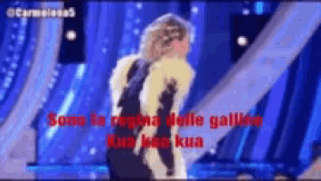 a woman in a fur coat is dancing on a stage with the words sono la regina delle galline on the bottom
