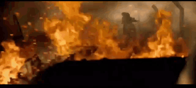 a group of people are standing in front of a fire .
