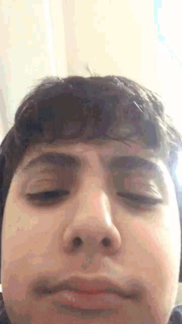 a close up of a man 's face with his eyes closed .